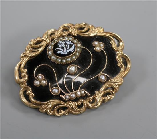 A Victorian gold plated, black enamel, split pearl and hardstone set mourning brooch, with foliate decoration, 56mm.